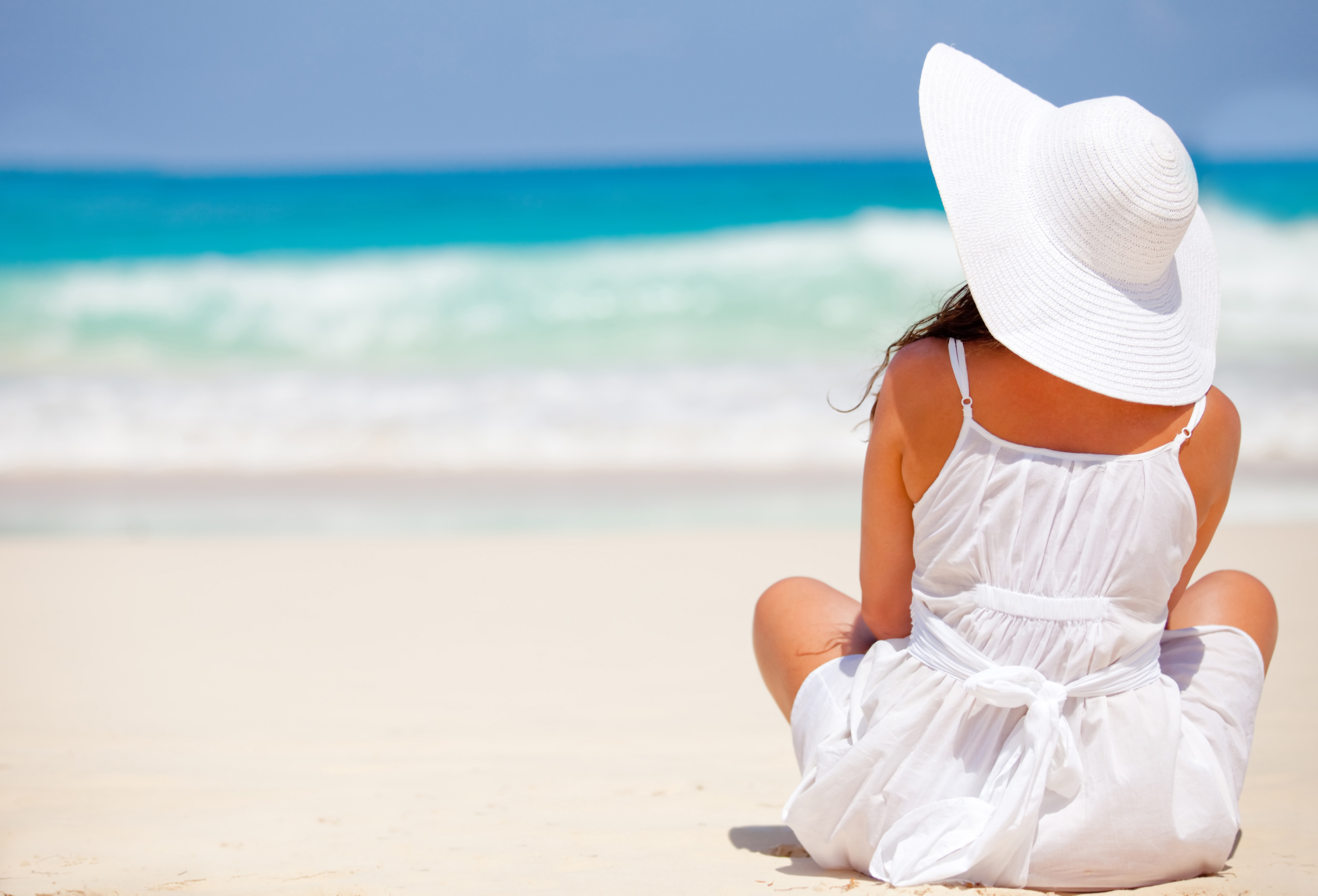 Peaceful woman at the beach contemplating the ocean and relaxing